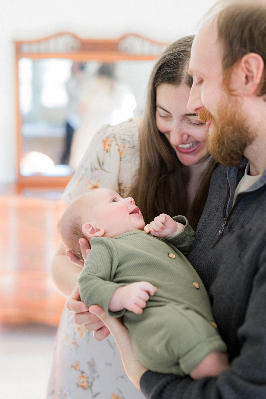 Parents sharing a laugh with baby Corbin Wesley in a Columbia newborn photography session by Love Tree Studios.