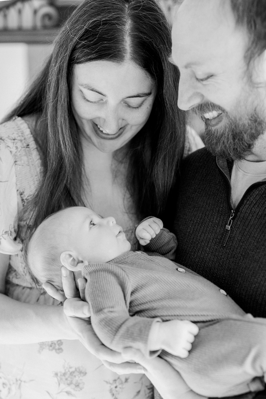 Baby Corbin Wesley gazing up at his parents during an in-home session by Love Tree Studios in Columbia, MO.