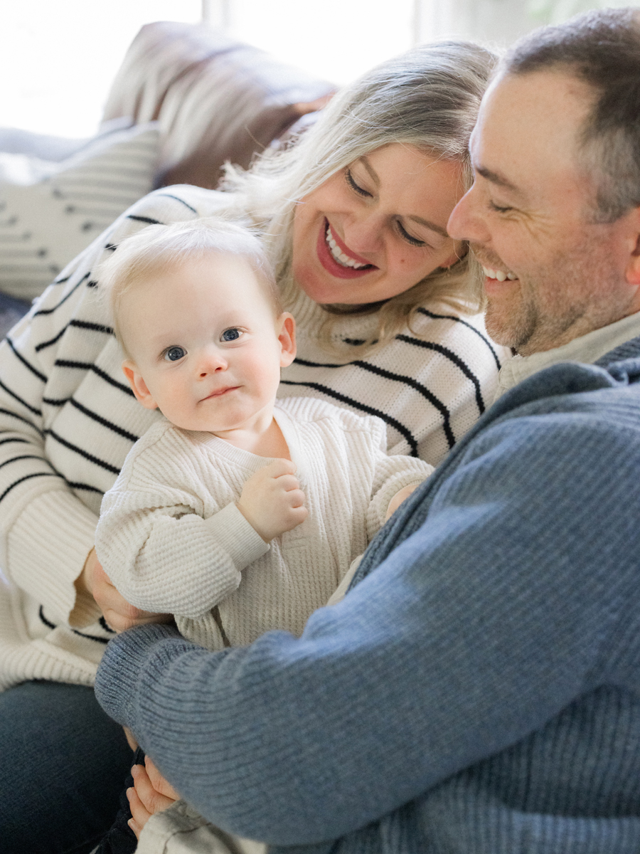 Close-up of baby smiling while sitting on the couch, photographed by Love Tree Studios, specializing in family photography in Columbia, MO.