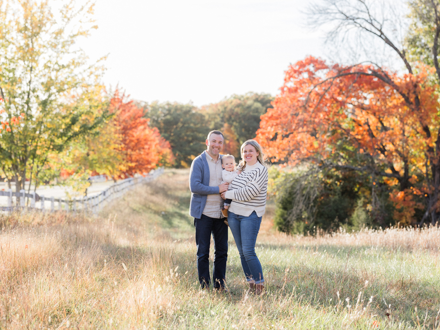 Outdoor family portrait surrounded by vivid autumn leaves, photographed by Love Tree Studios in Columbia, MO.