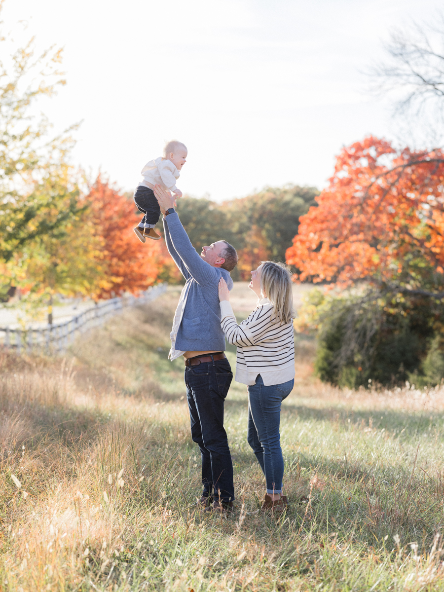 Family playing in a field of fall leaves, captured by Love Tree Studios in Columbia, MO.