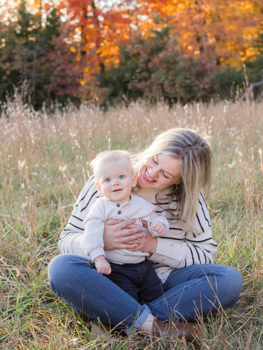 Schaffner family smiling together with colorful foliage in the background, photographed by Love Tree Studios in Columbia, MO.