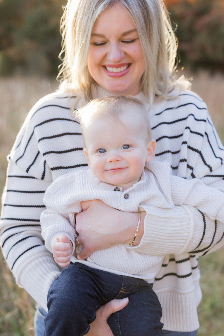 Mother cuddling baby in an autumnal outdoor setting, captured by Love Tree Studios in Columbia, MO.