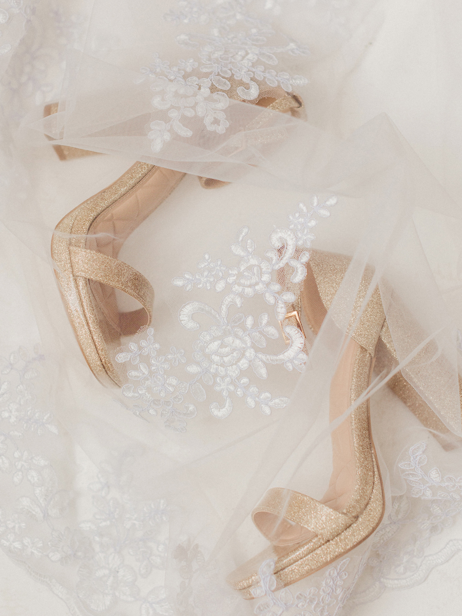 Elegant bridal shoes surrounded by a veil at Cooper's Ridge Wedding Venue, photographed by Love Tree Studios.