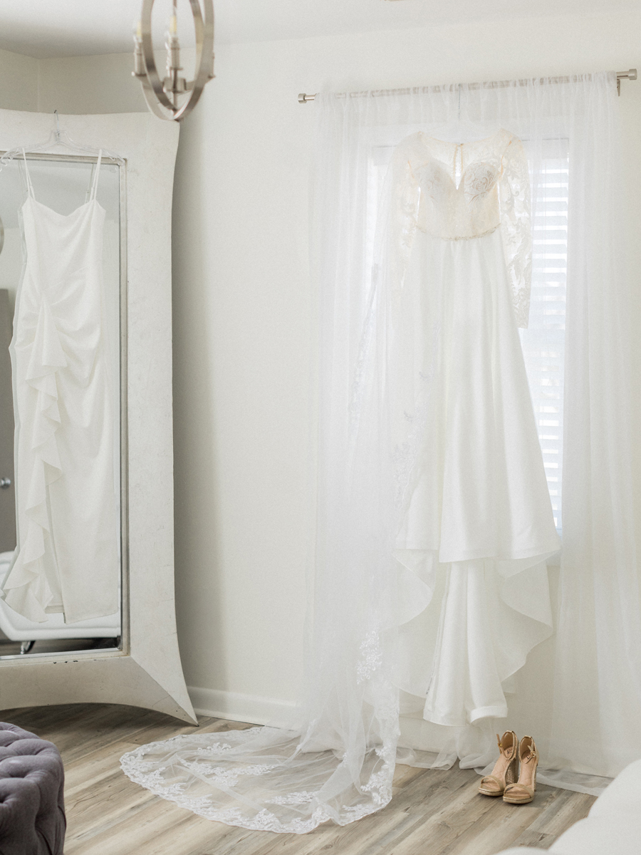 Bride’s lace gown hanging in preparation for the wedding at Cooper's Ridge Wedding Venue, captured by Love Tree Studios.