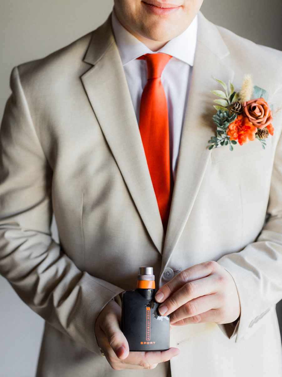 Groom’s light beige suit and burnt orange tie details at Cooper's Ridge Wedding Venue, captured by Love Tree Studios.