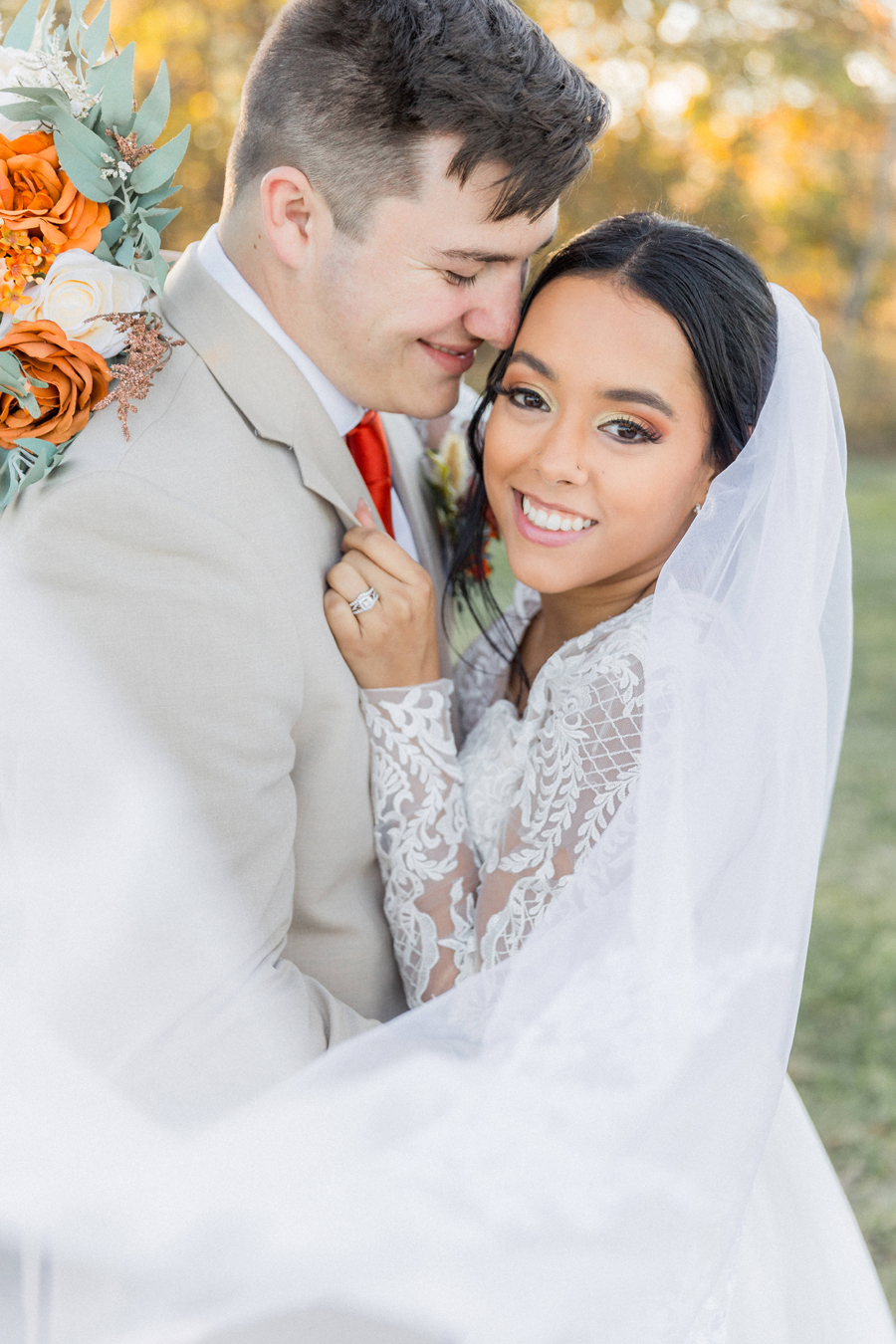 Bride and groom framed by autumn foliage at Cooper's Ridge Wedding Venue, captured by Love Tree Studios.