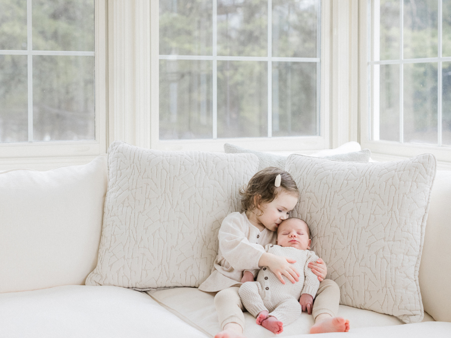 Big sister Millie snuggles her newborn brother Harry during their Columbia Missouri Newborn Photography session - Love Tree Studios.