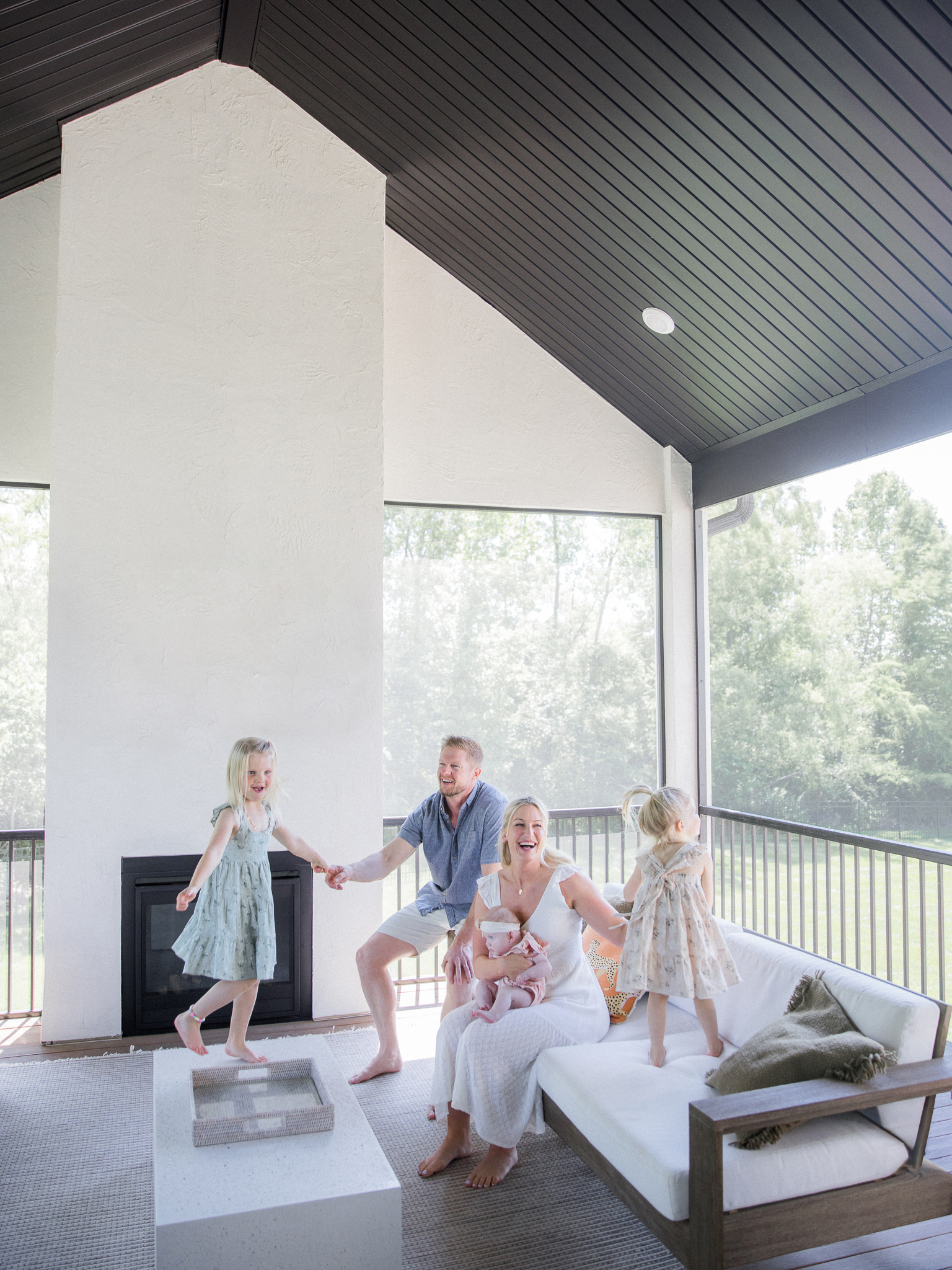 Playful family moment on the porch during an in-home newborn photography session in Missouri with Love Tree Studios.
