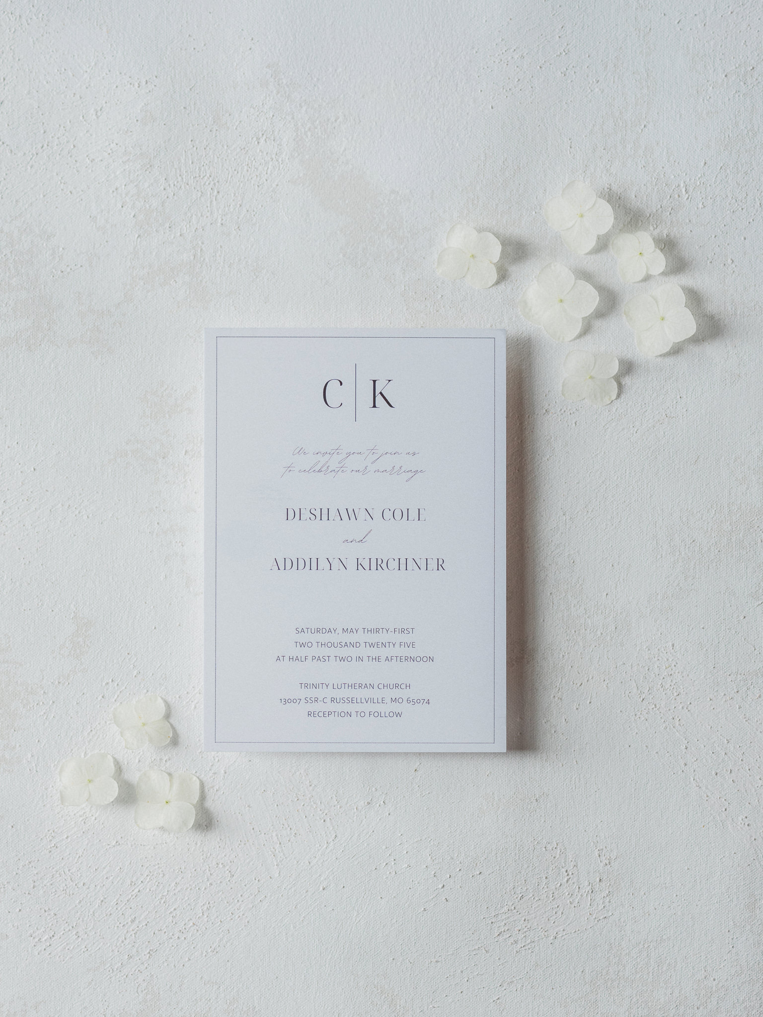 Wedding invitation with white petals on a soft background captured by Love Tree Studios for Jefferson City wedding photography in Jefferson City, Missouri.