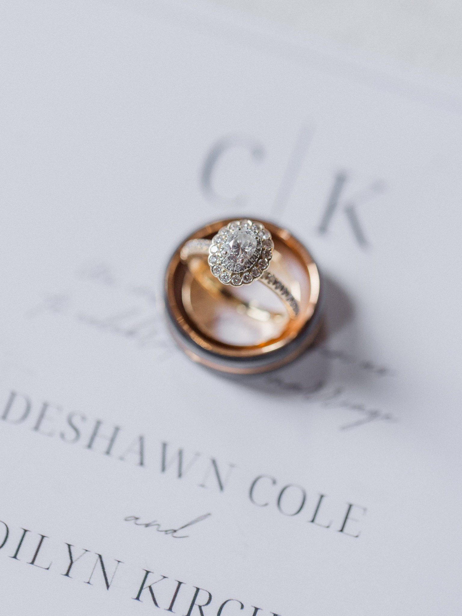 Close-up of wedding rings on invitation paper captured by Love Tree Studios for Jefferson City wedding photography in Jefferson City, Missouri.