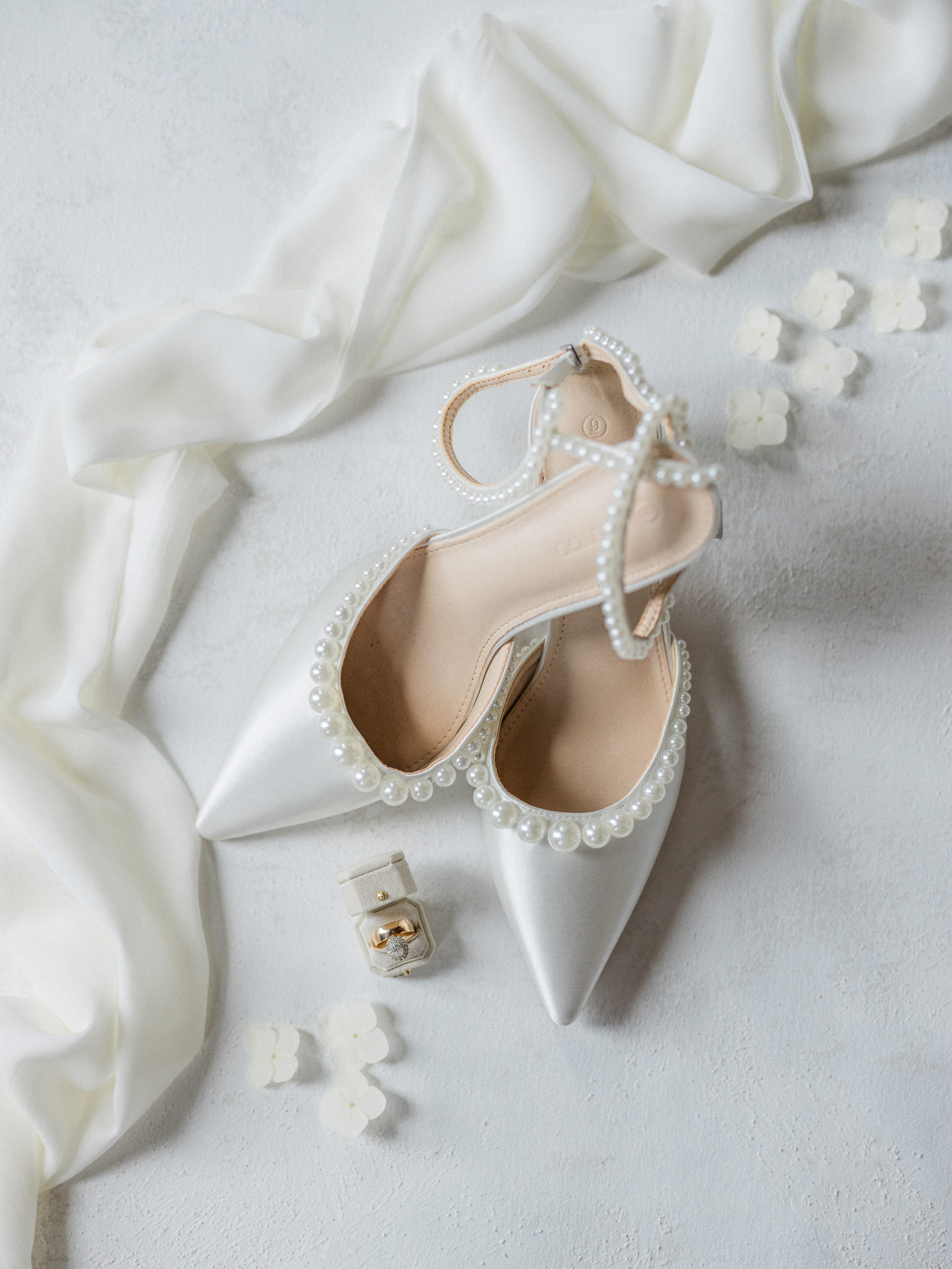 Bridal shoes and ring box styled with white flowers captured by Love Tree Studios for Jefferson City wedding photography in Jefferson City, Missouri.