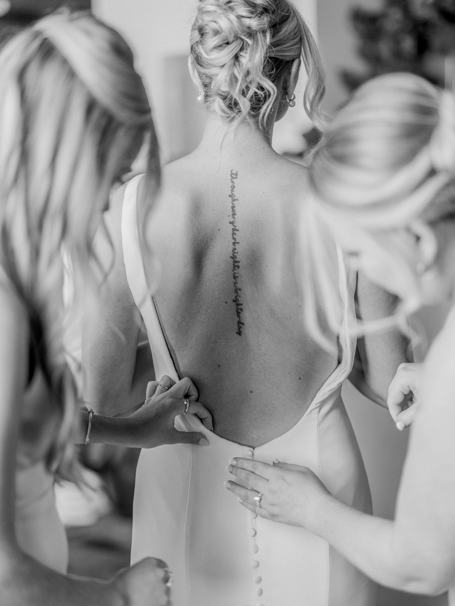 Bridesmaids helping bride into her dress captured by Love Tree Studios for Jefferson City wedding photography in Jefferson City, Missouri.