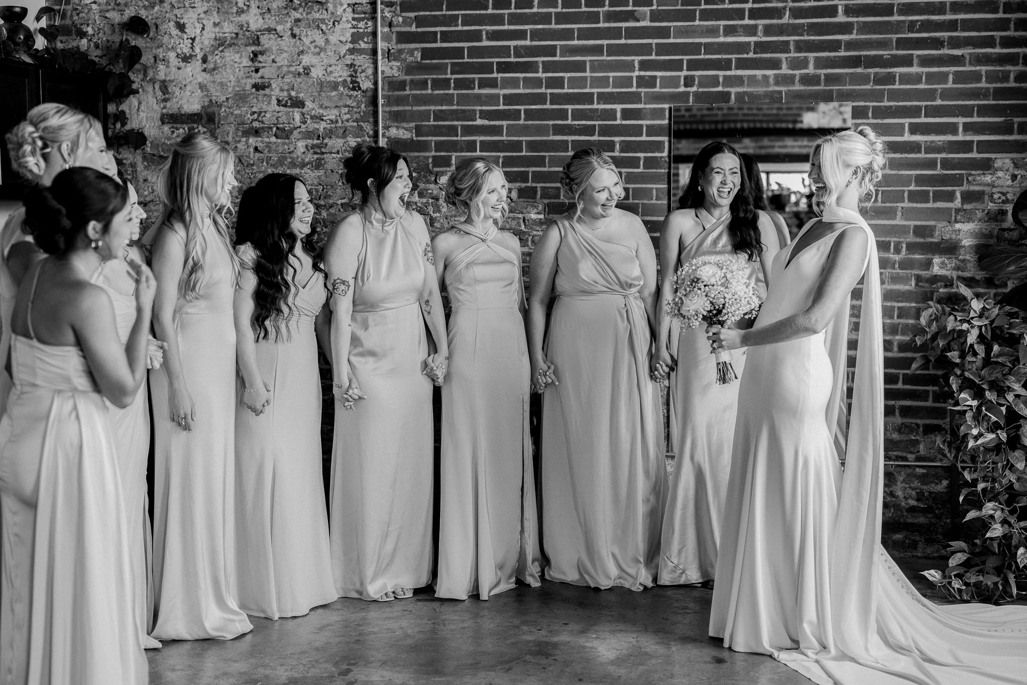 Bride reveals final look to bridesmaids with laughter captured by Love Tree Studios for Jefferson City wedding photography in Jefferson City, Missouri.