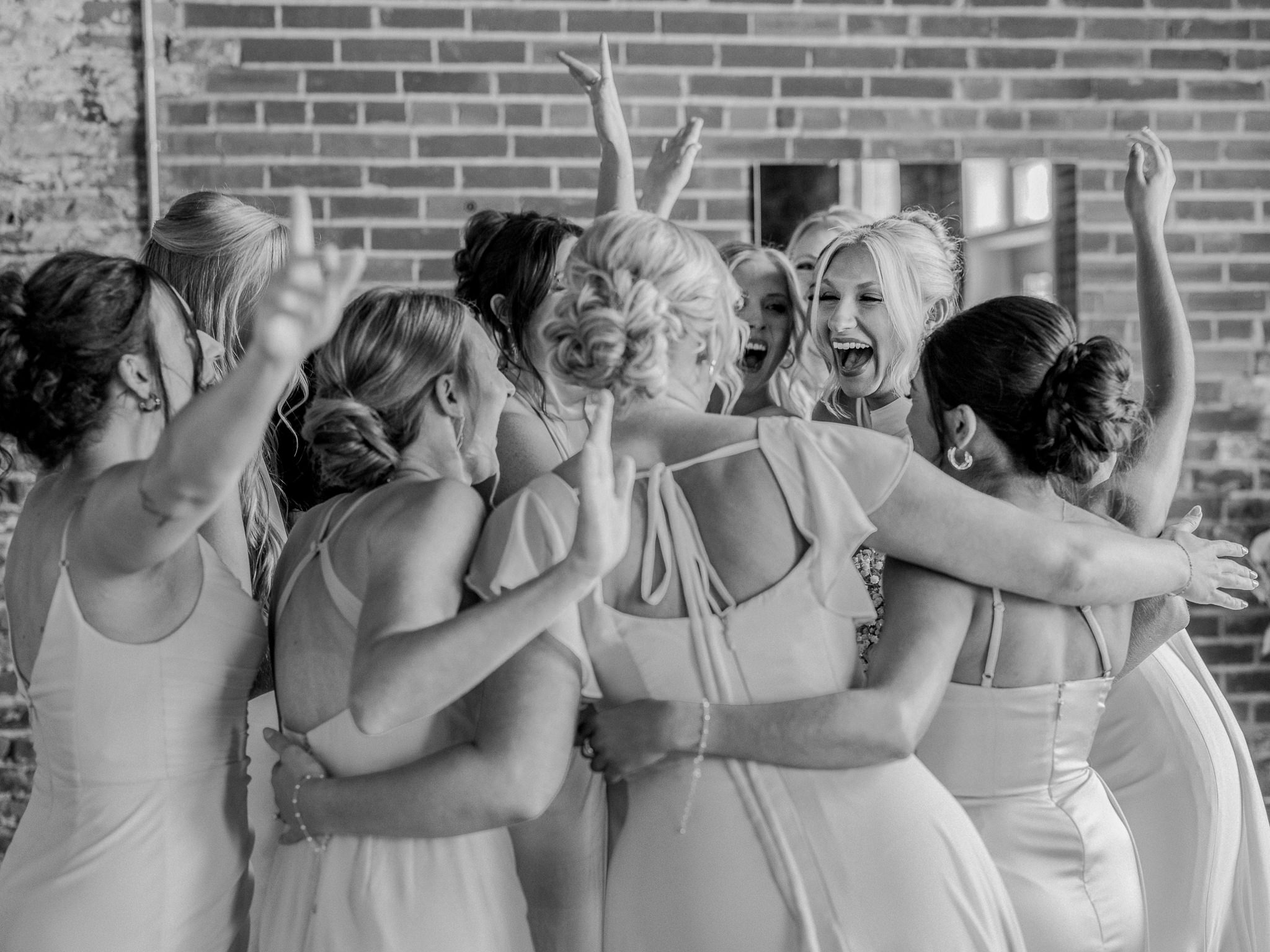 Bride and bridesmaids in joyful group hug captured by Love Tree Studios for Jefferson City wedding photography in Jefferson City, Missouri.