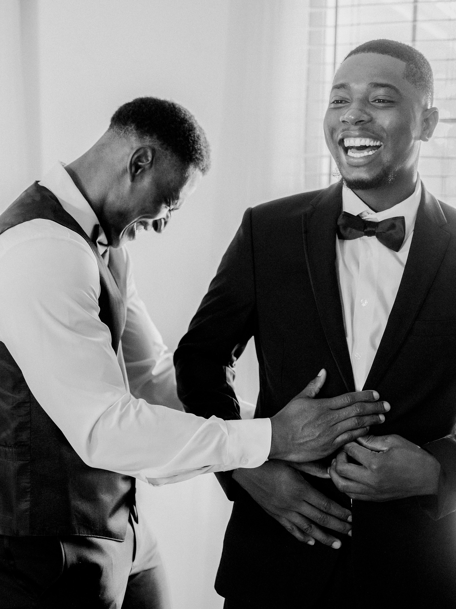 Groom laughing while getting dressed for the wedding captured by Love Tree Studios for Jefferson City wedding photography in Jefferson City, Missouri.

