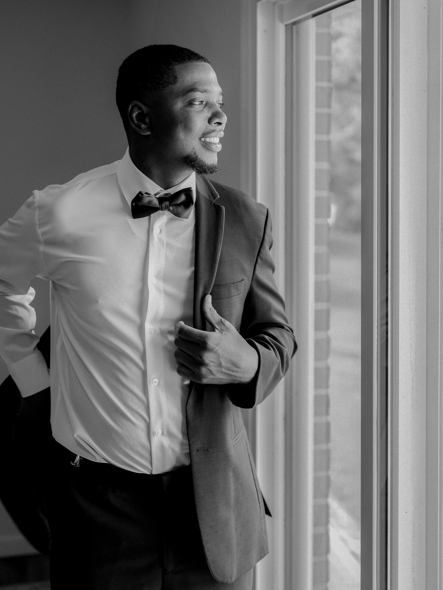 Groom looking out window with anticipation before the ceremony captured by Love Tree Studios for Jefferson City wedding photography in Jefferson City, Missouri.
