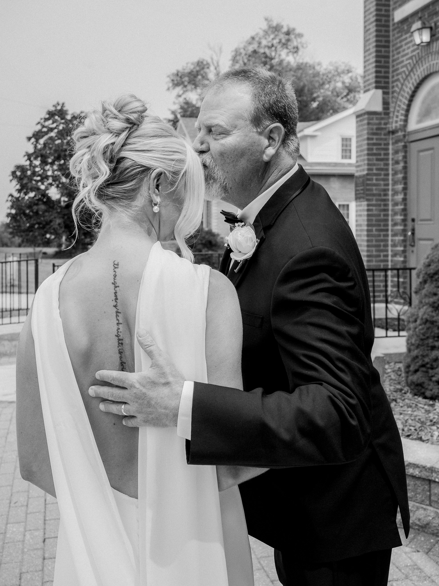 Father of the bride kissing her forehead in a quiet moment captured by Love Tree Studios for Jefferson City wedding photography in Jefferson City, Missouri.