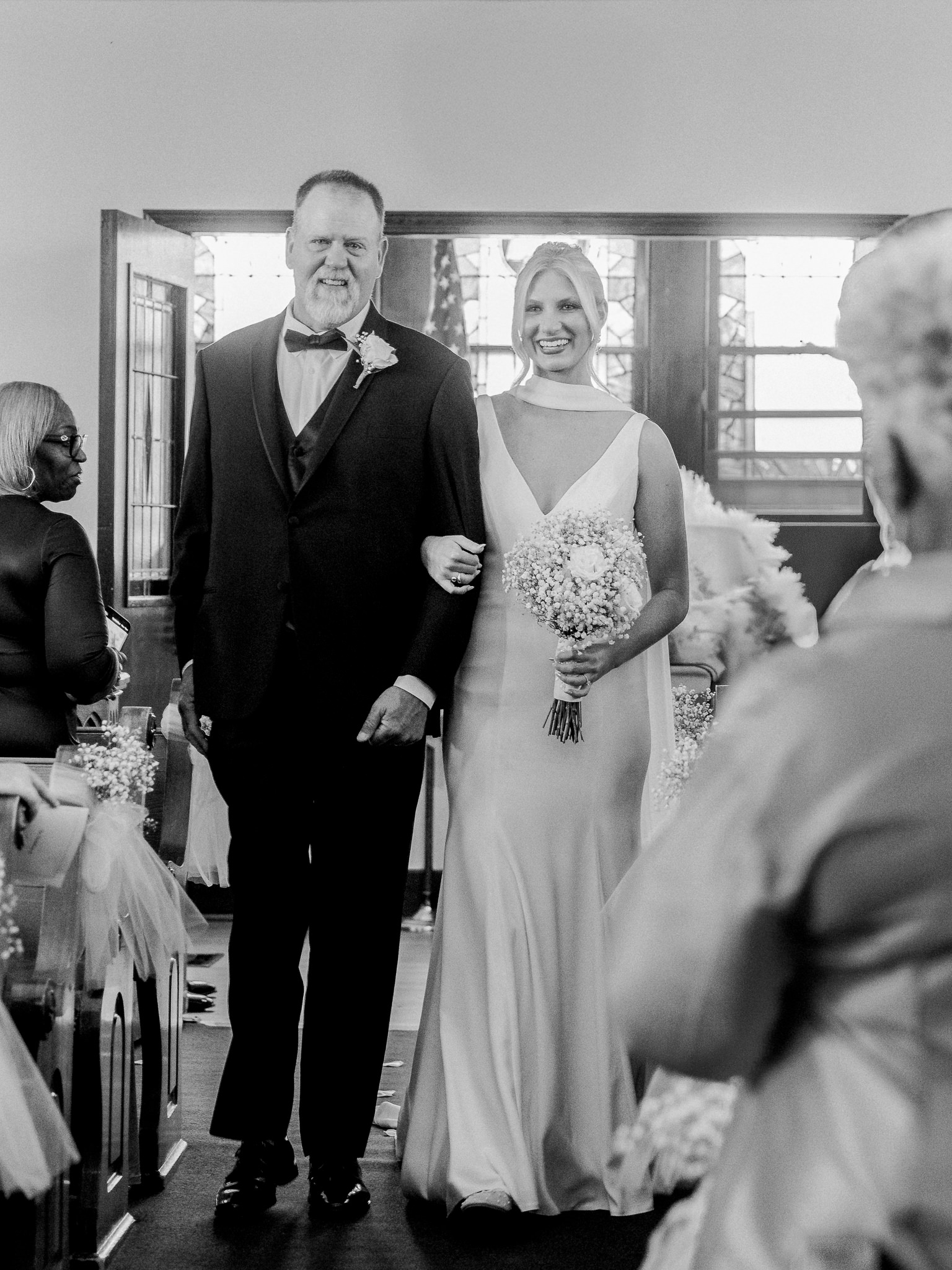 Bride walking down the aisle with her father during ceremony captured by Love Tree Studios for Jefferson City wedding photography in Jefferson City, Missouri.

