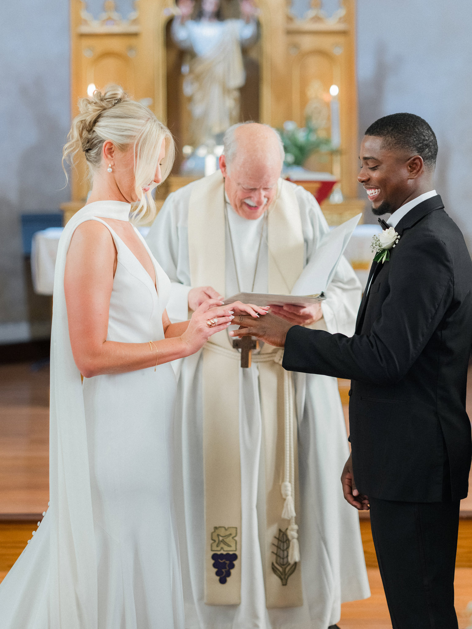 Bride places ring on groom’s finger during heartfelt ceremony at the altar — captured by Missouri wedding photographer.