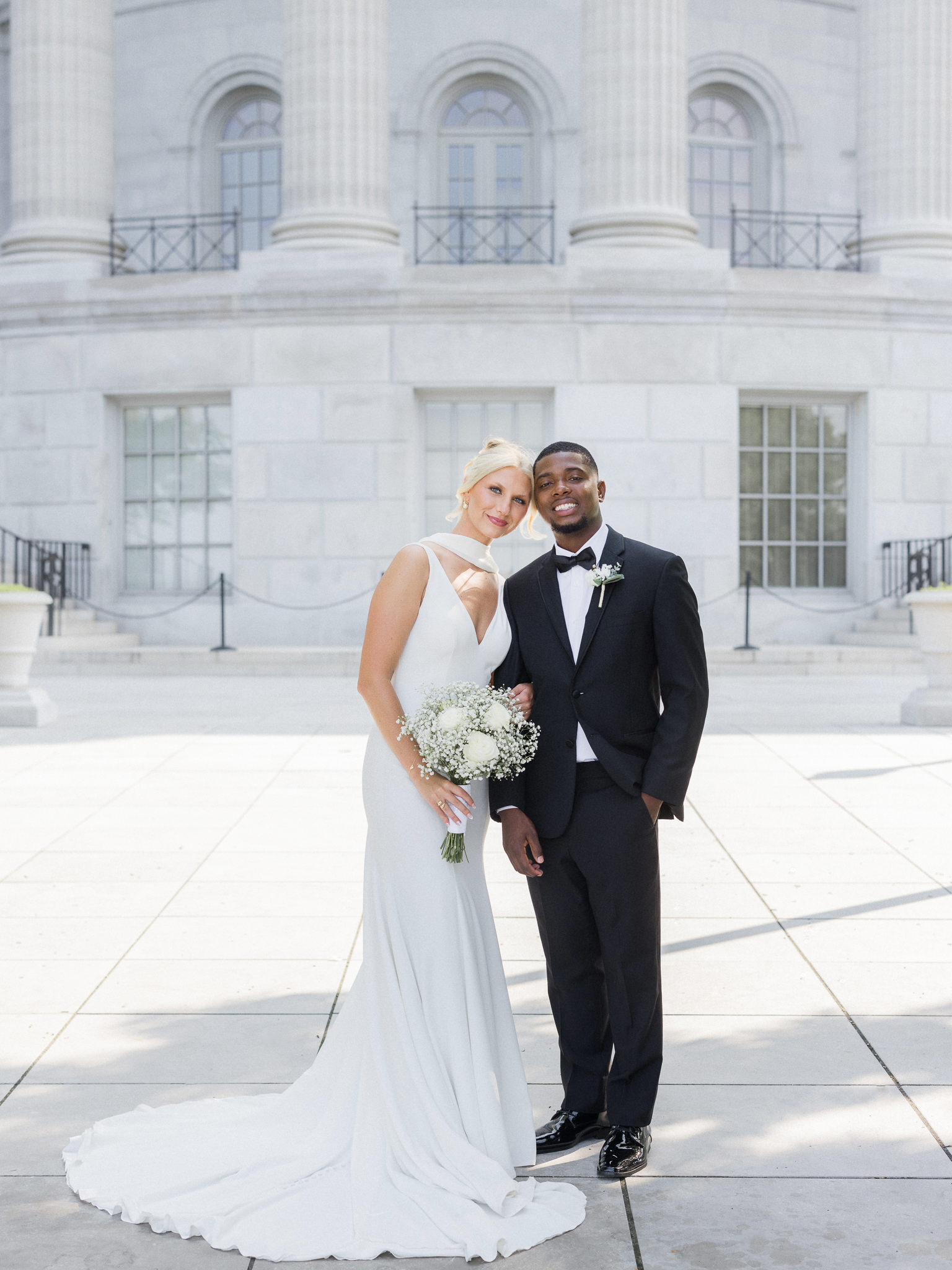 Elegant wedding portrait of the bride and groom outside a marble courthouse — image by Missouri wedding photographer Love Tree Studios.