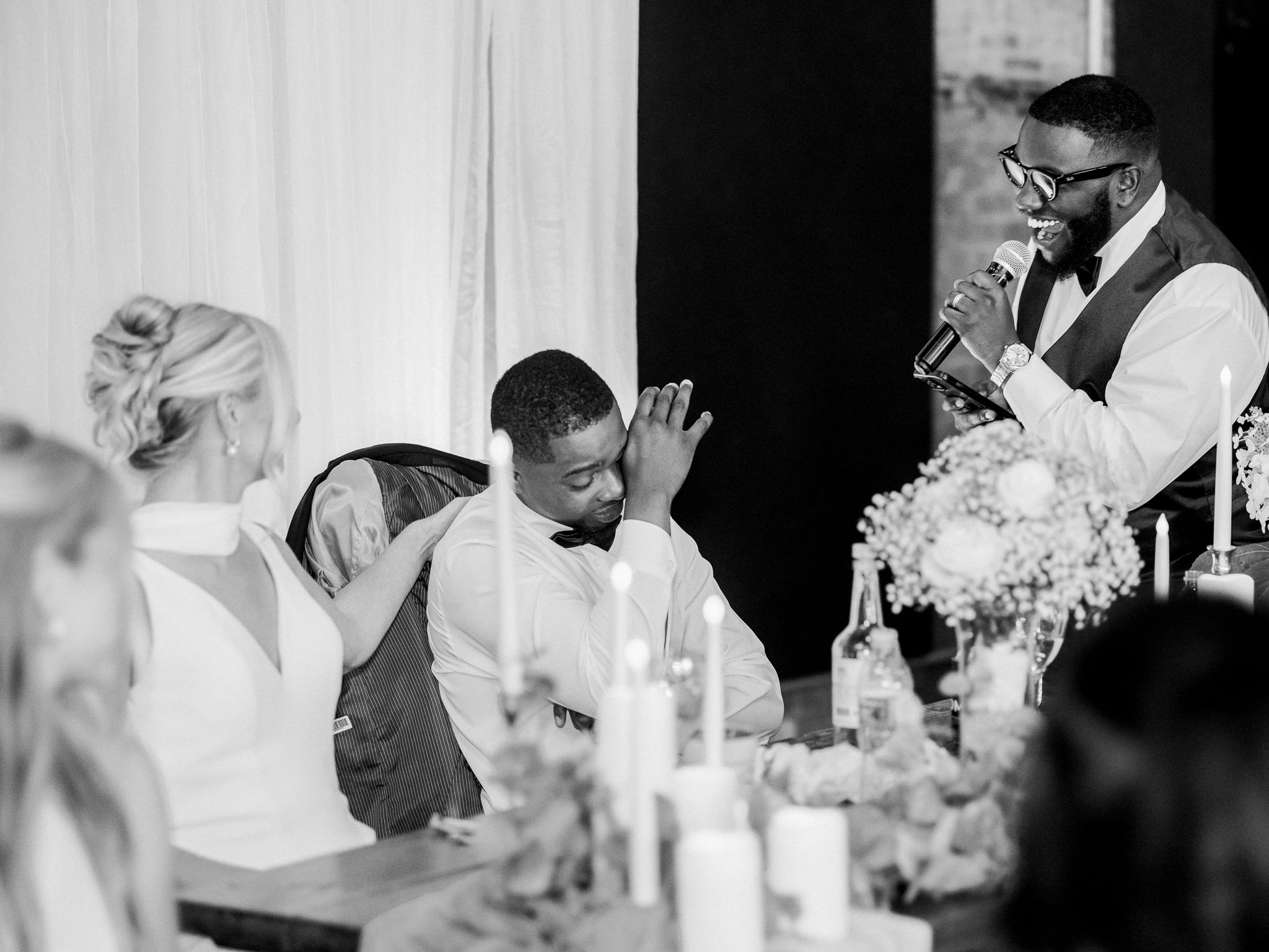 Wedding guests raise glasses in a joyful group toast during the couple’s reception.