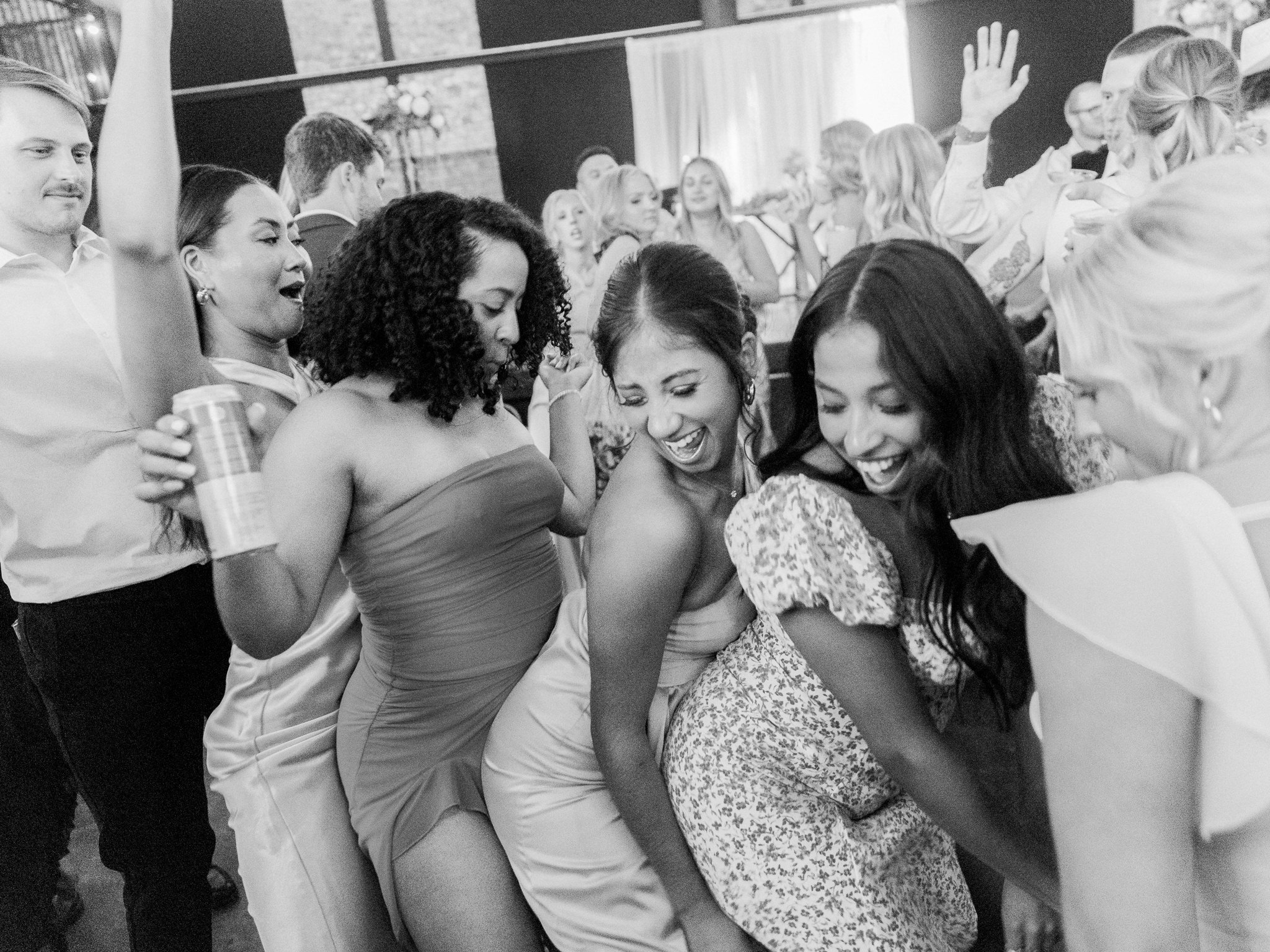 Group of wedding guests dance and celebrate late into the night on the reception floor.