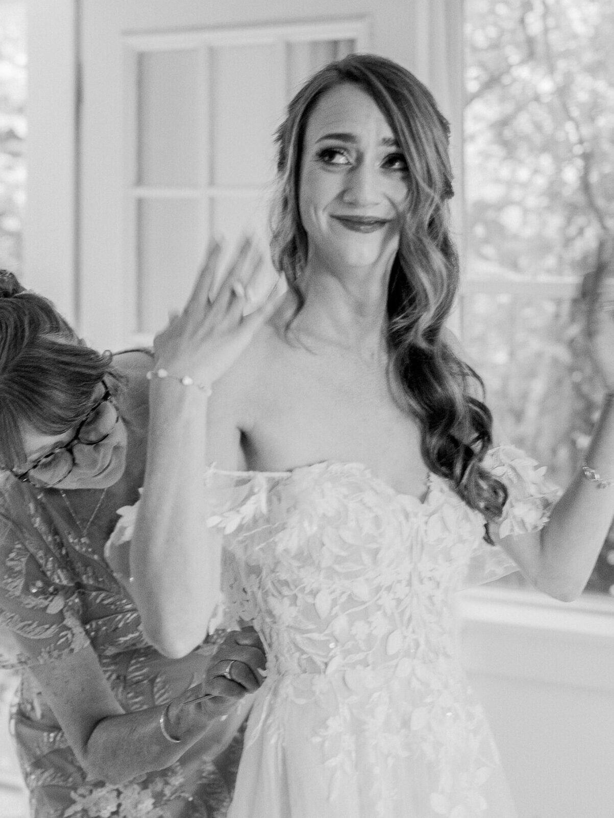 Bride gets emotional as her mom helps her into the gown, full of love.