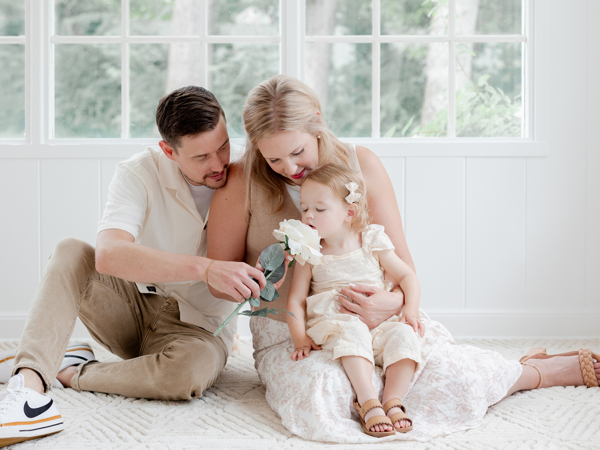Parker smelling a white flower during her family’s Columbia, Missouri studio photo session with Love Tree Studios.
