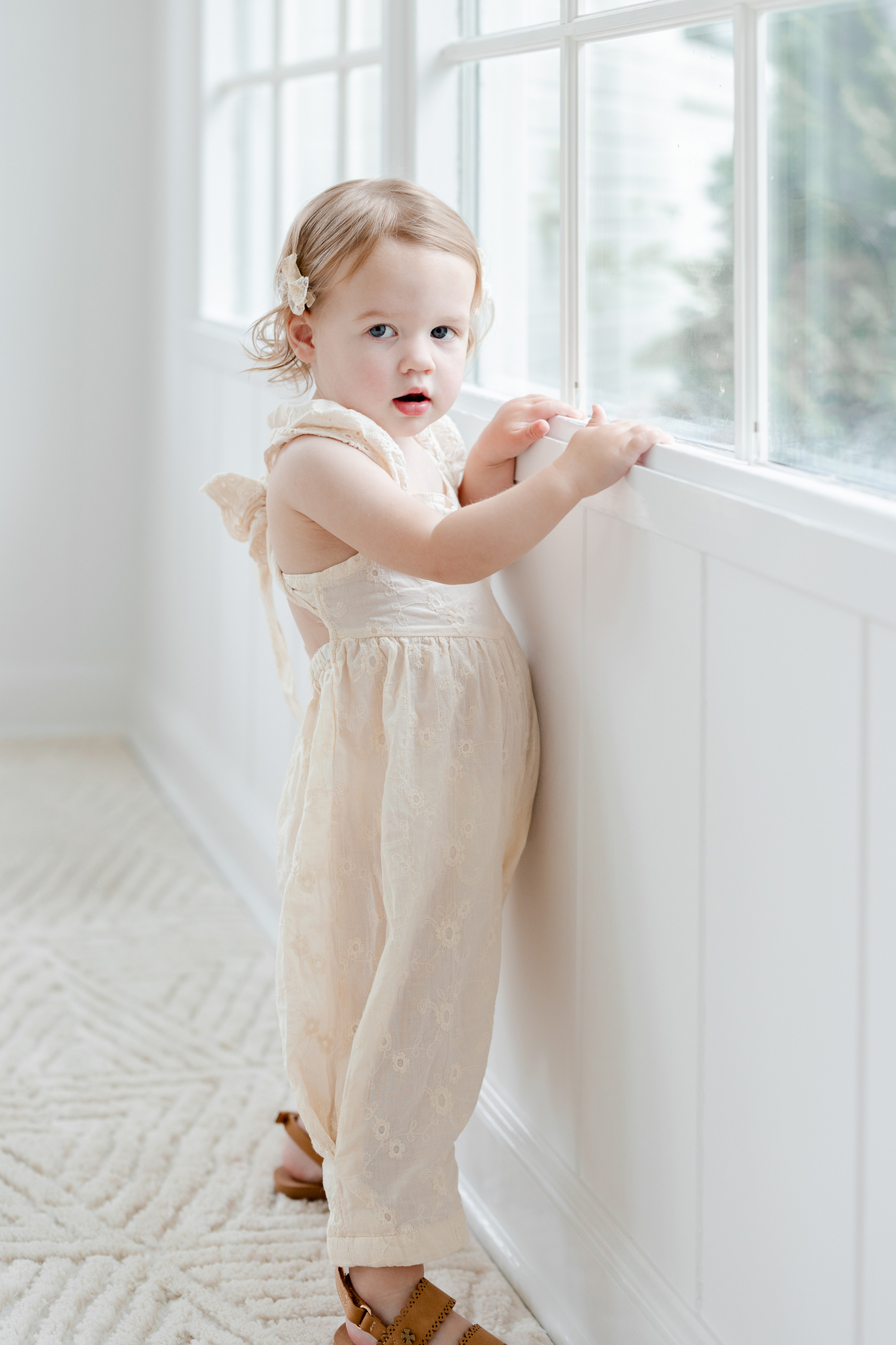 Parker gazing out the window during her studio family session with Love Tree Studios in Columbia, Missouri, capturing sweet and natural moments from these studio family photos Missouri.