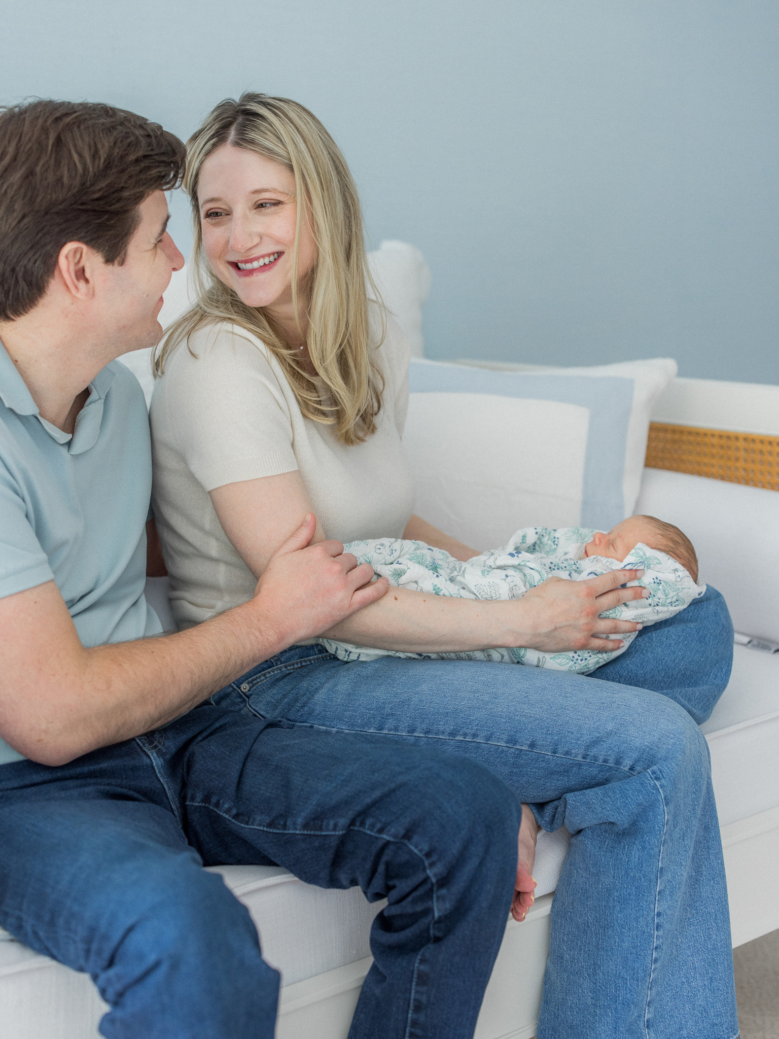 Mom smiling at dad while holding their newborn son at home in Columbia Missouri.