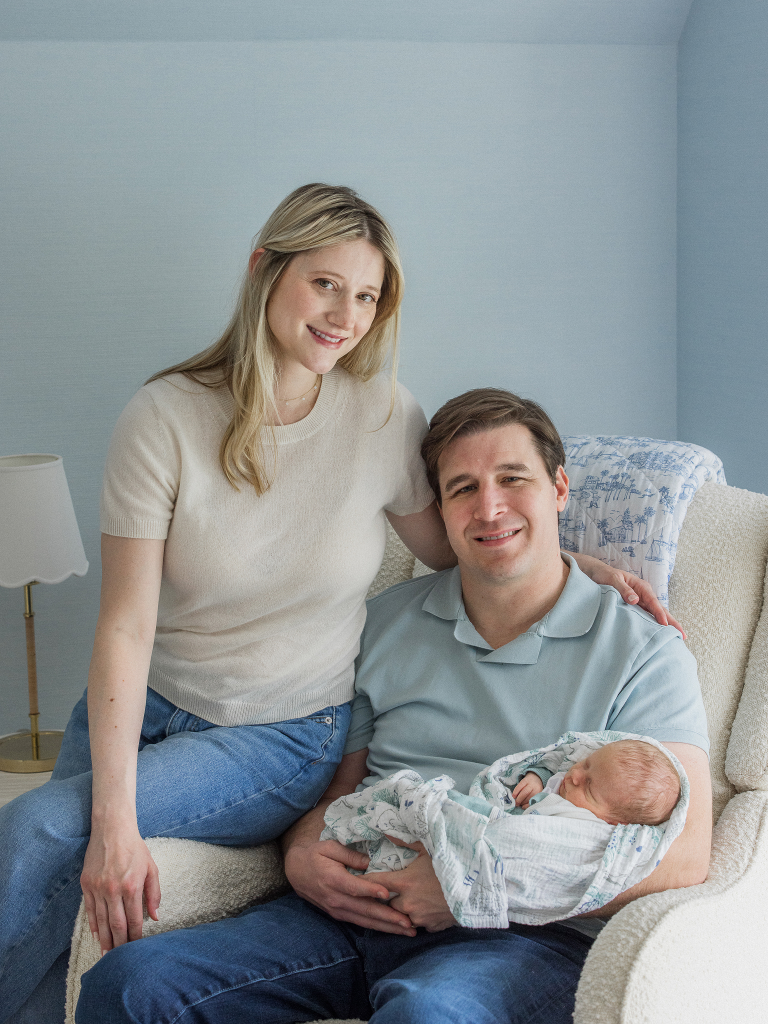 Family portrait with mom, dad, and baby Win in a cozy rocker during their Columbia Missouri newborn session.