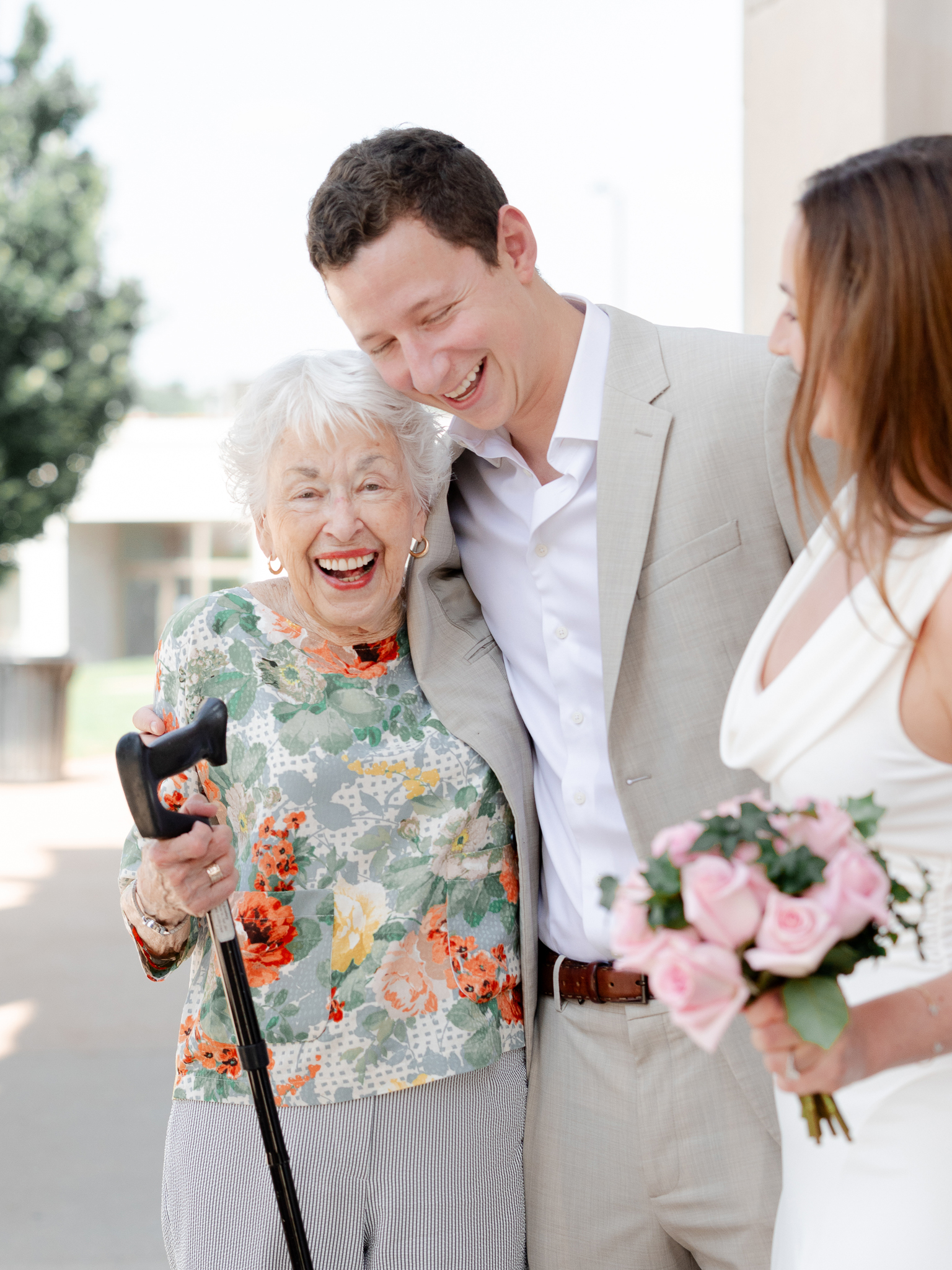 Candid portrait of Arthur laughing with Madison and her grandmother outside the courthouse – courthouse wedding in Columbia Missouri captured by Love Tree Studios.