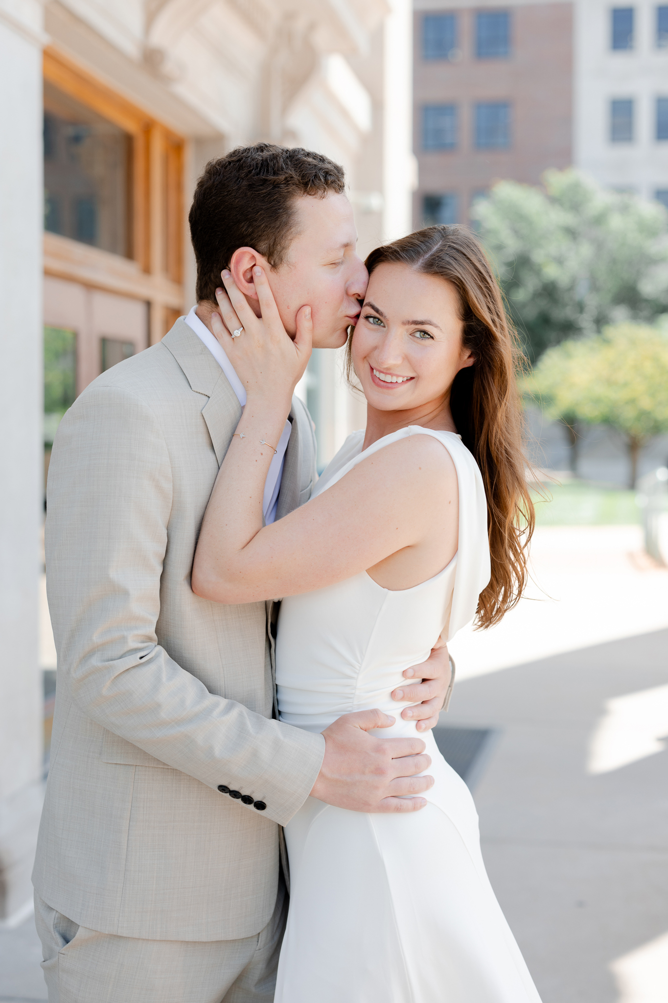 Arthur kissing Madison’s cheek while she smiles at the camera – romantic courthouse wedding in Columbia Missouri photography by Love Tree Studios.