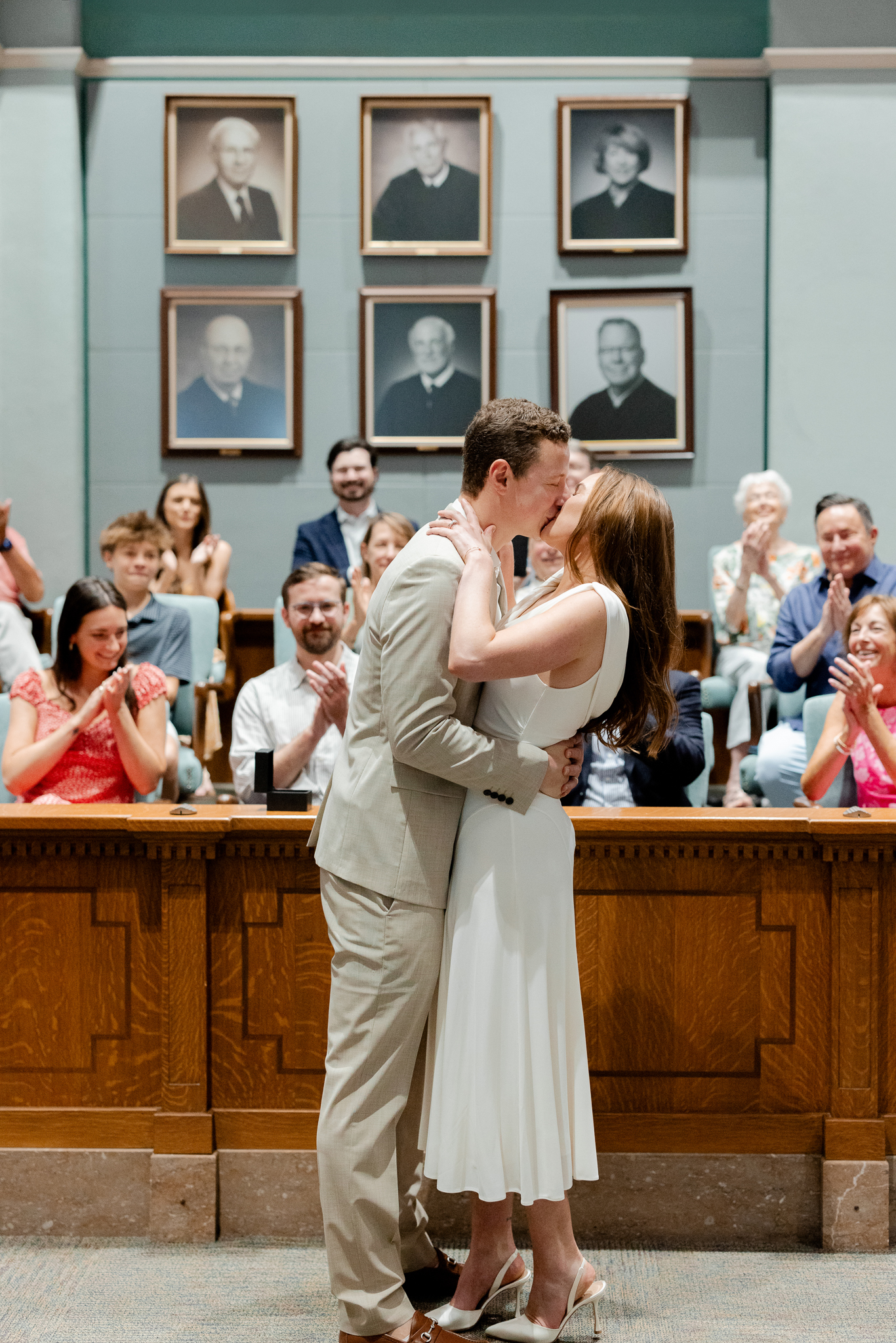 Bride and groom sharing their first kiss in front of loved ones inside the Boone County Courthouse – courthouse wedding in Columbia Missouri captured by Love Tree Studios.