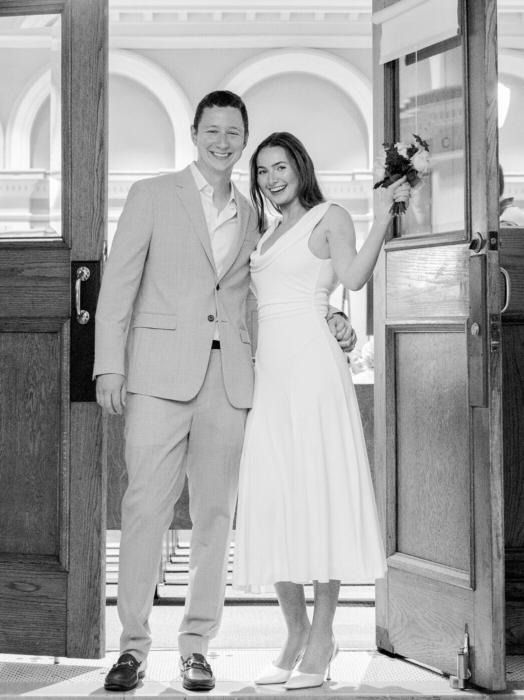Arthur and Madison smiling and standing in the courthouse doorway after their ceremony – courthouse wedding in Columbia Missouri photography by Love Tree Studios.
