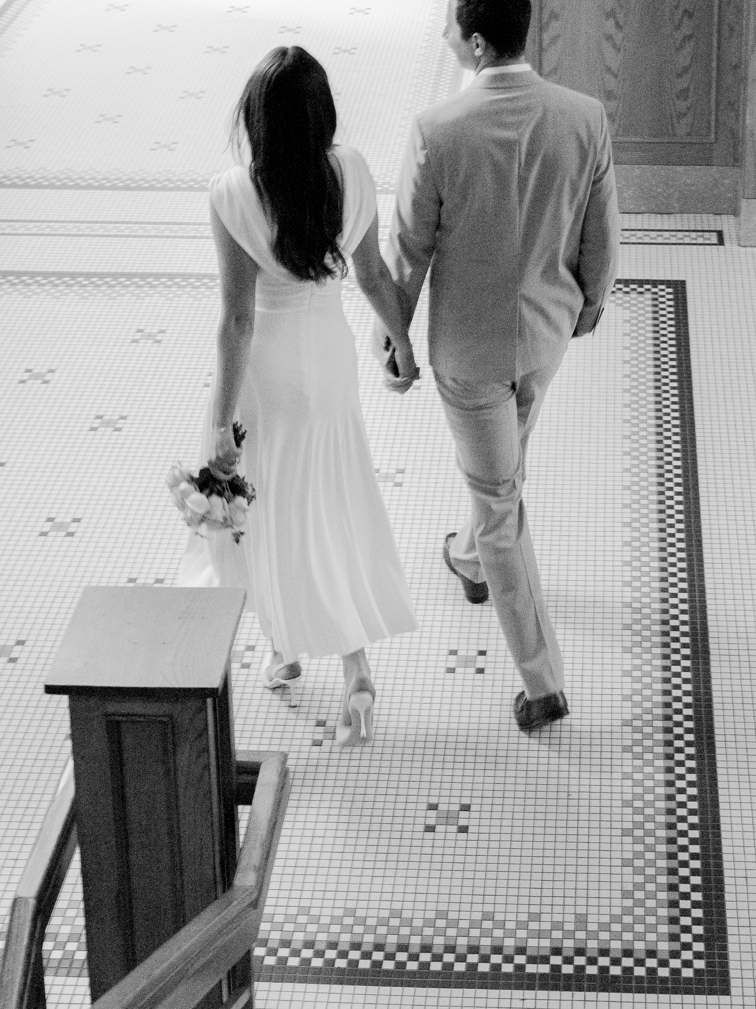 Bride and groom walking hand in hand through the courthouse hallway after their ceremony – courthouse wedding in Columbia Missouri by Love Tree Studios.