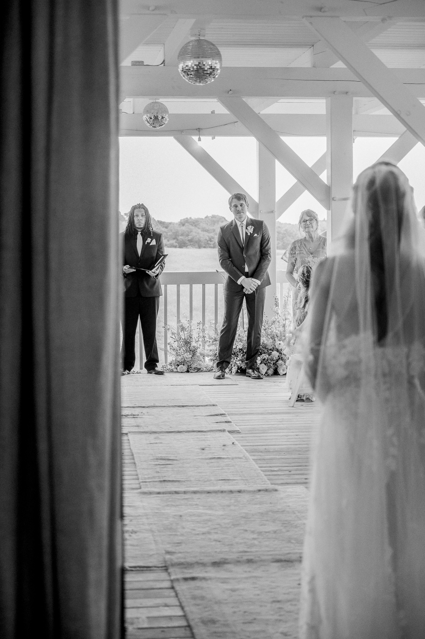 Groom watches as the bride walks down the aisle, taken from behind her veil at a Blue Bell Farm wedding ceremony.