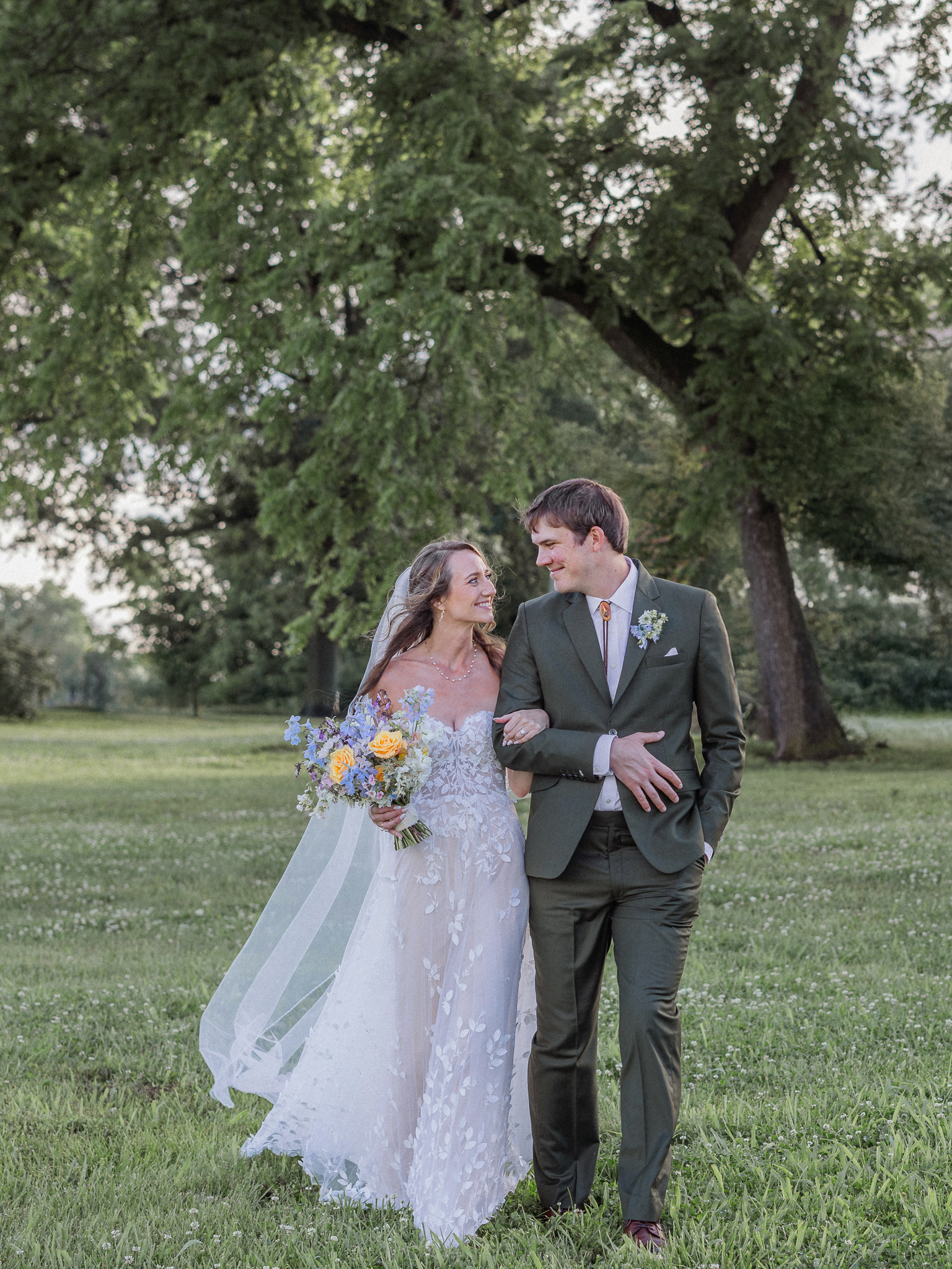 Hand in hand, soaking up the last light of day at their Blue Bell Farm wedding.