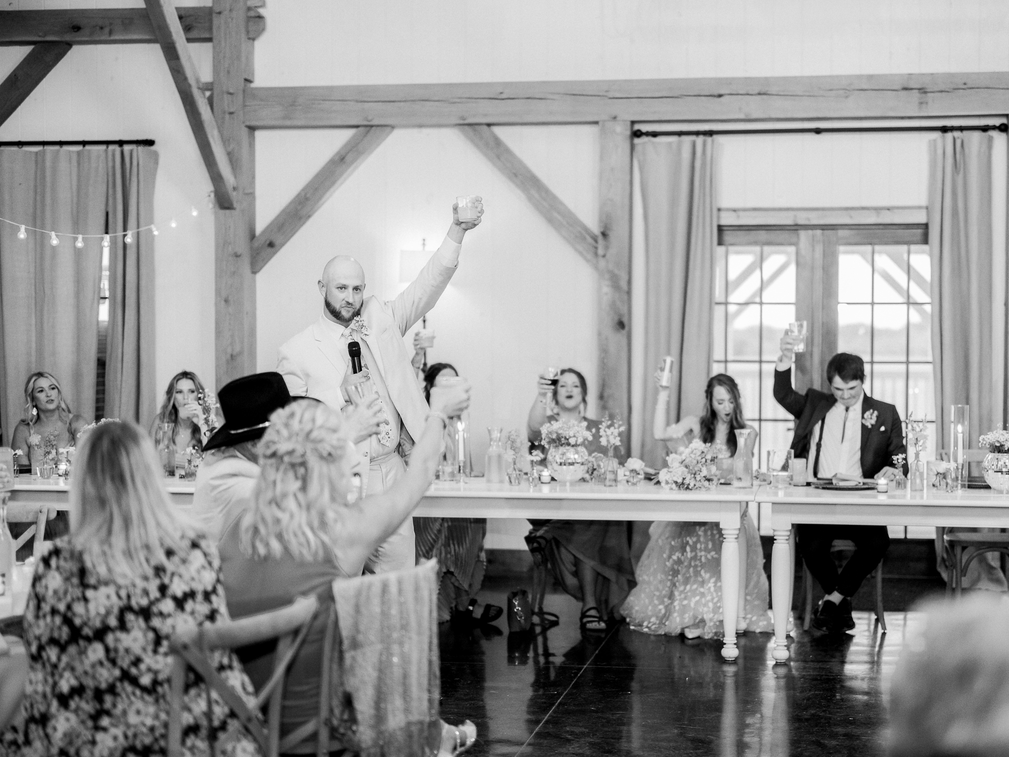 Champagne glasses lifted high in celebration at this joyful Blue Bell Farm wedding.