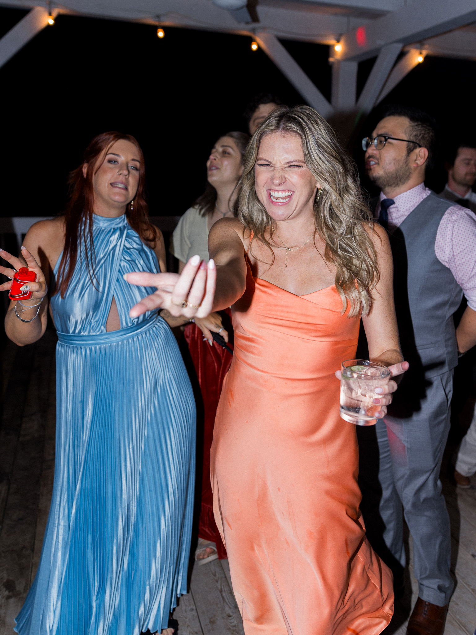 Wedding guests dance and sing with energy and laughter during the evening celebration of a Blue Bell Farm wedding, photographed by