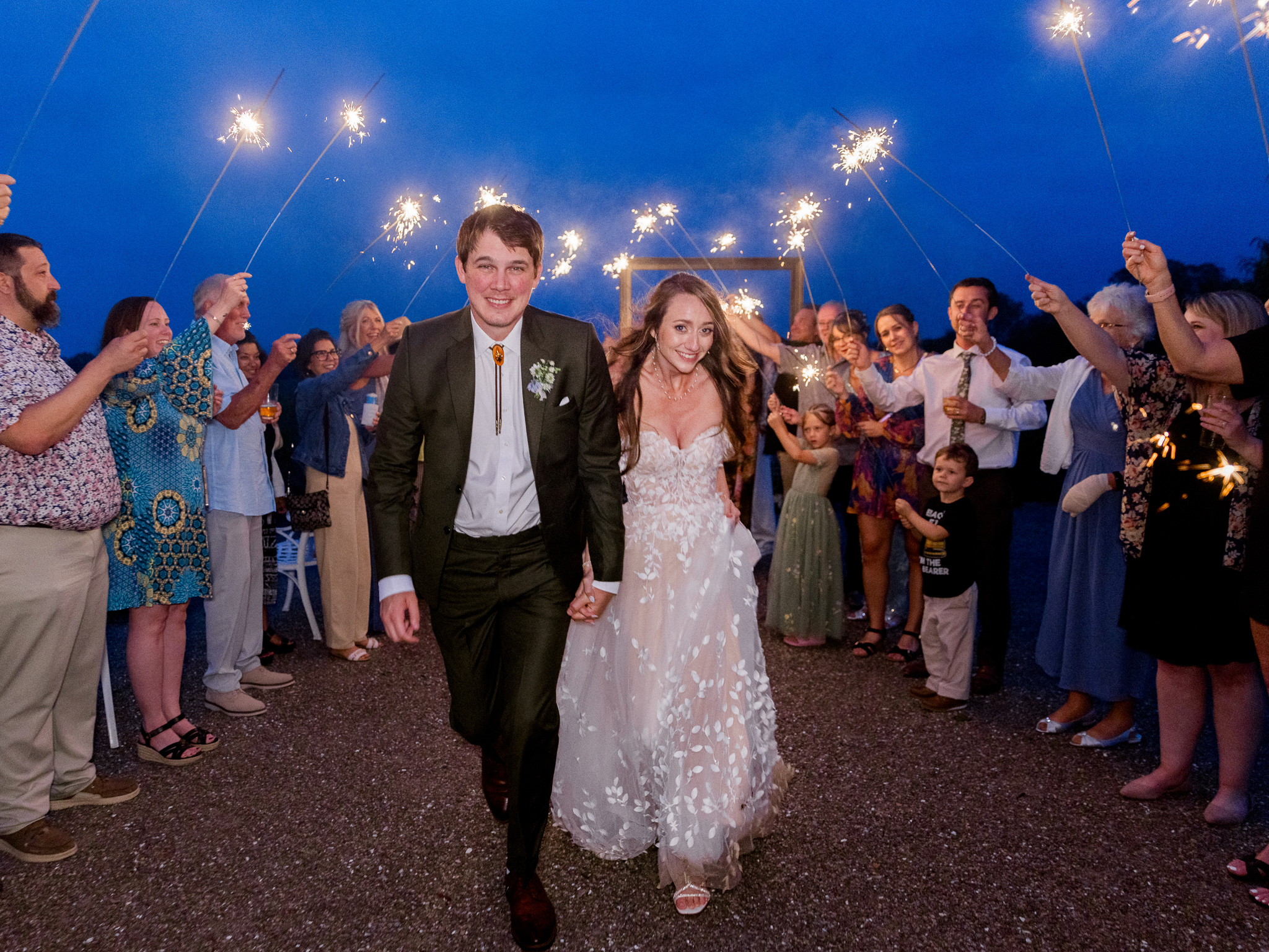 The bride and groom run and laugh together through sparklers during the evening festivities at a Blue Bell Farm wedding, captured by Love Tree Studios.
