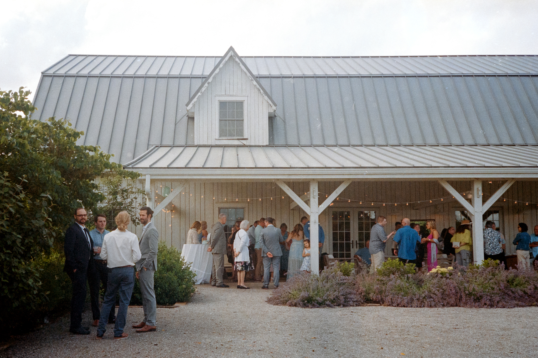Guests mingling outside the barn during a relaxed cocktail hour at Blue Bell Farm.