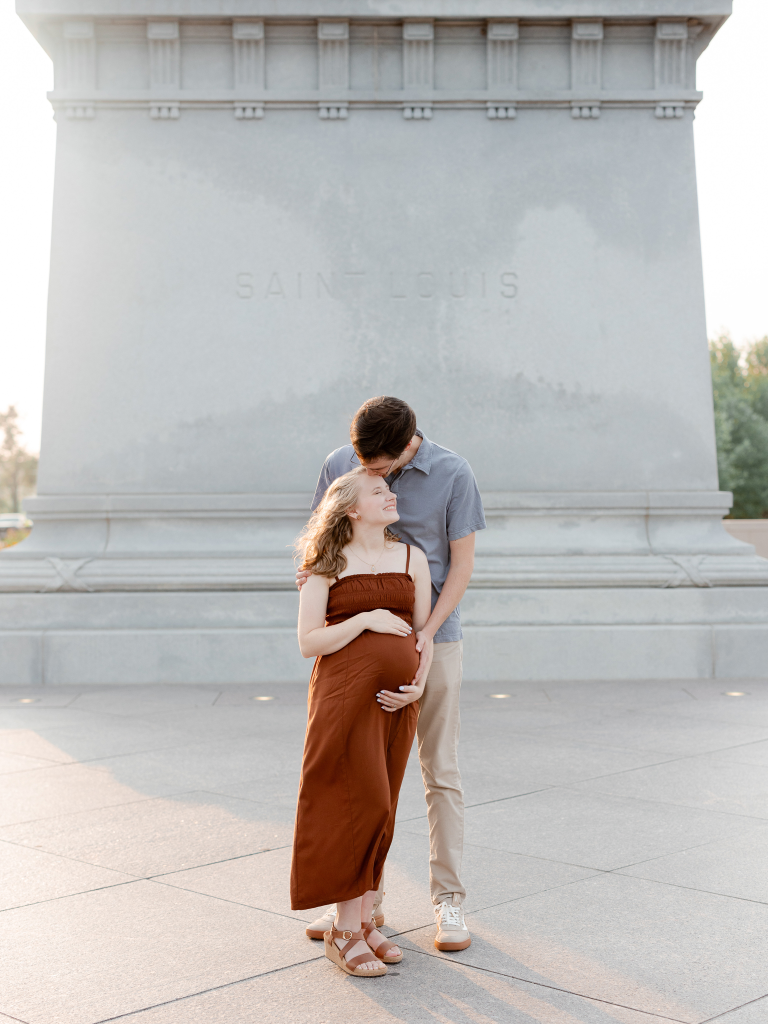 Couple smiling during their maternity session in St. Louis at Art Hill, photographed by Love Tree Studios.