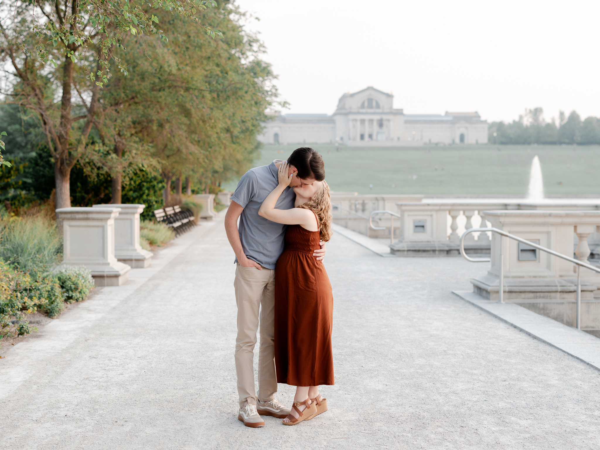 Expecting couple shares a tender kiss along the pathways of Art Hill in St. Louis, maternity photos by Love Tree Studios.