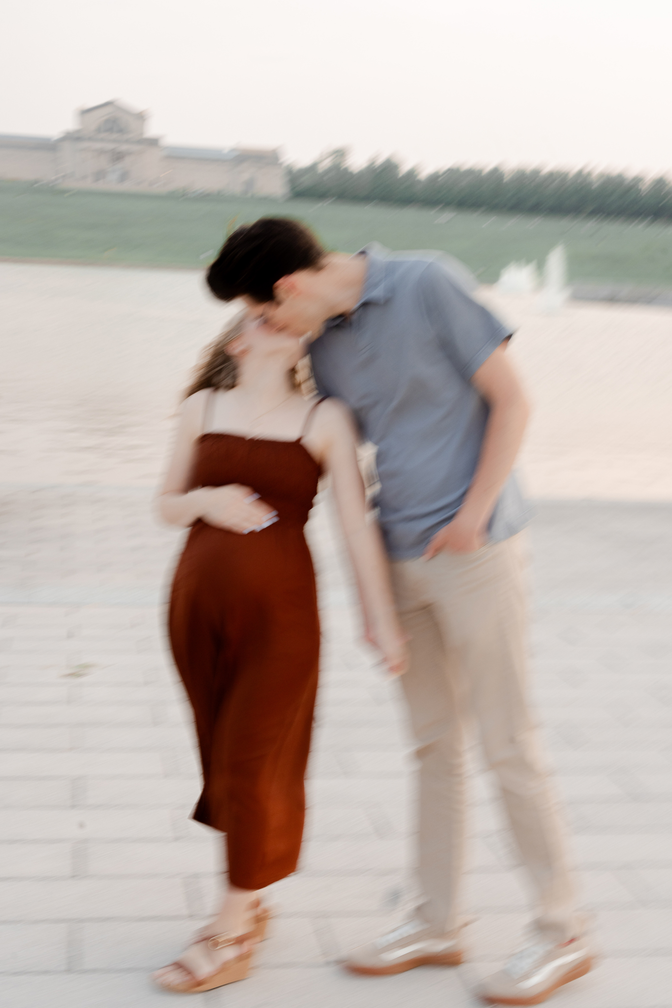 Artistic blurred image of a couple leaning in for a kiss during their maternity session at Art Hill in St. Louis, photographed by Love Tree Studios.