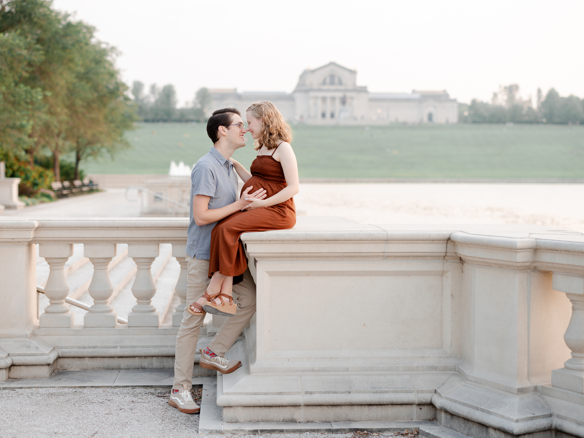 A couple embraces during their maternity session at Art Hill in St. Louis, captured by Love Tree Studios.
