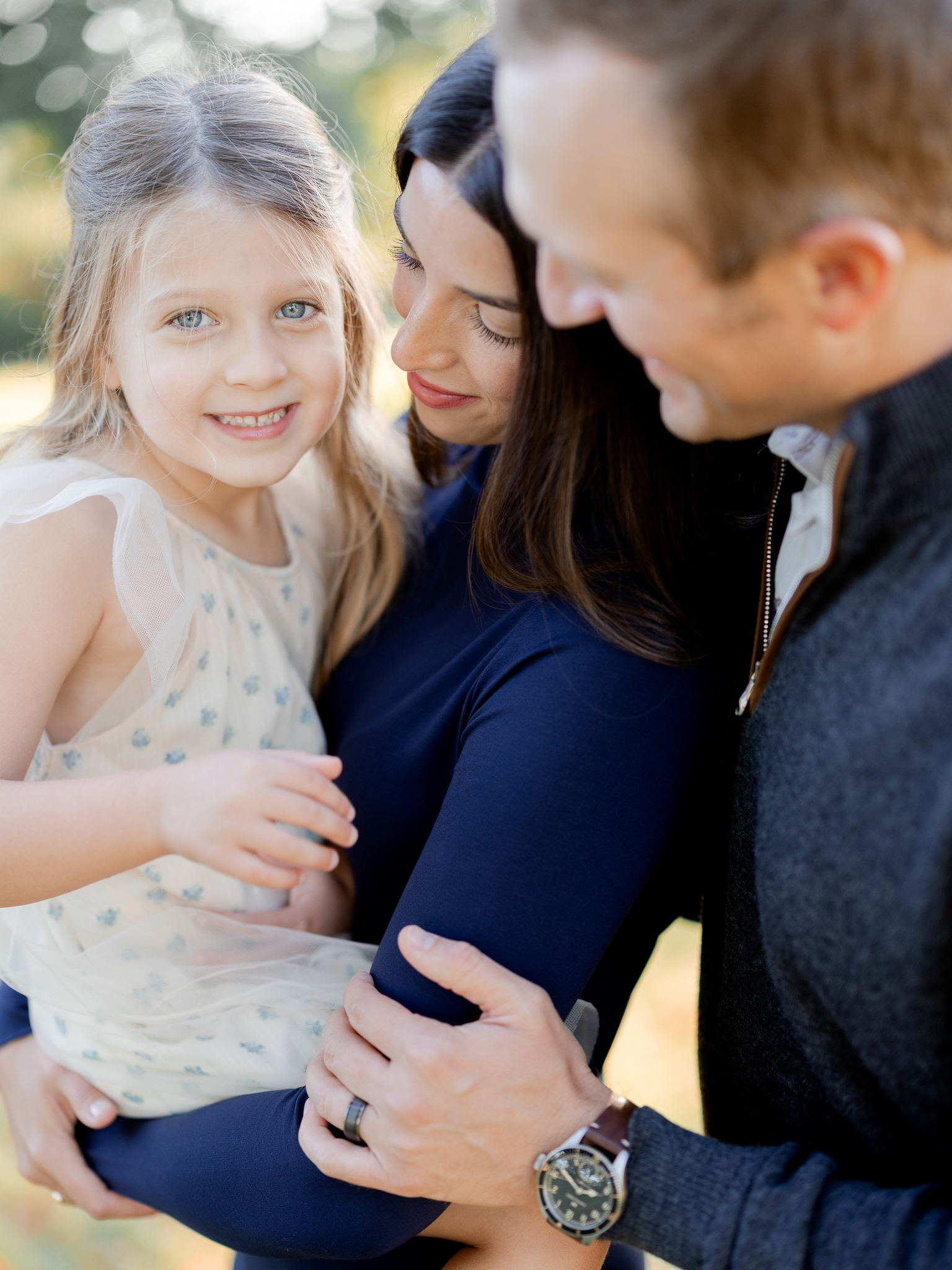 Sweet moment with daughter smiling in her mother’s arms during sunrise family photos in Columbia Missouri.