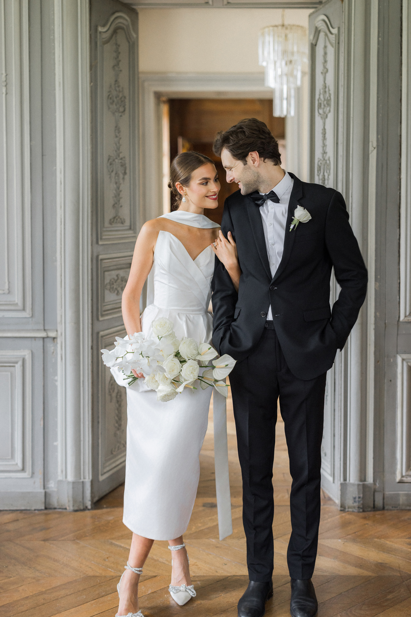 Bride and groom walking hand in hand across the parquet floors of Château de Thauvenay during their elegant destination wedding shoot in Sancerre, France.