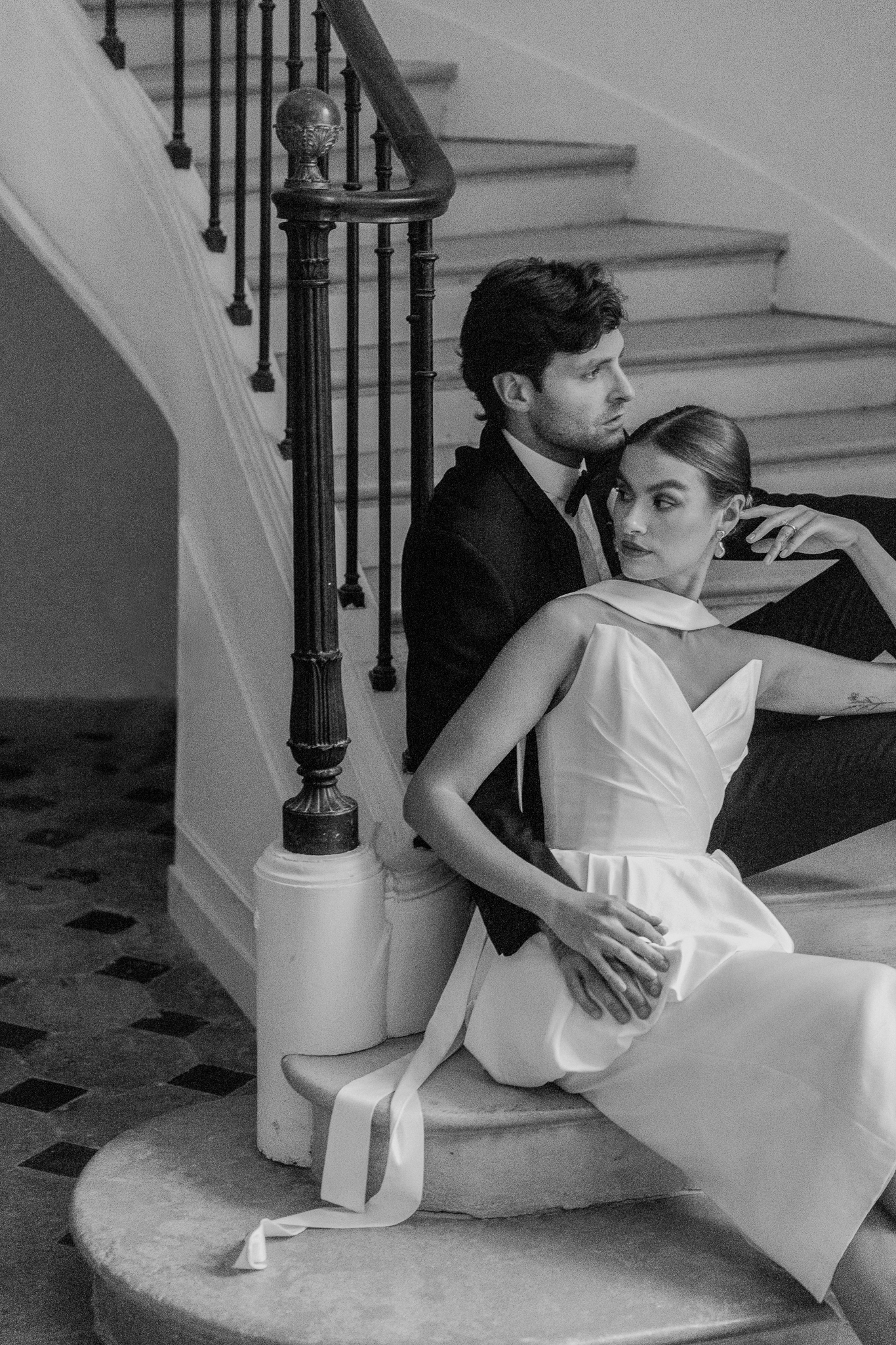 Fine art portrait of bride and groom seated together on the curved staircase at Château de Thauvenay, captured by Love Tree Studios during a French destination wedding editorial.